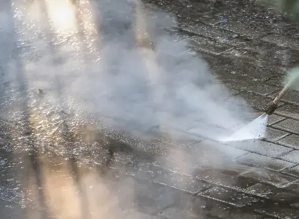 Pressure washer cleaning paving slabs