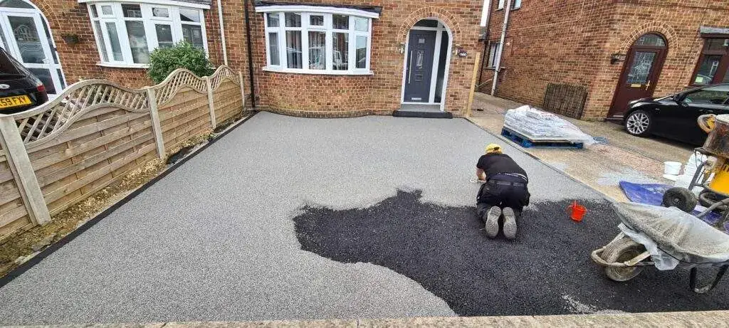Resin being trowelled onto a driveway