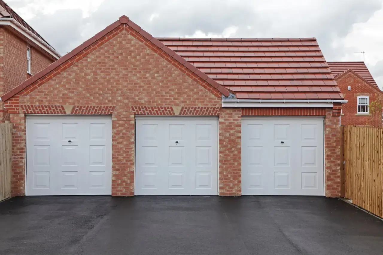 Smooth tarmac driveway in front of a row of garages